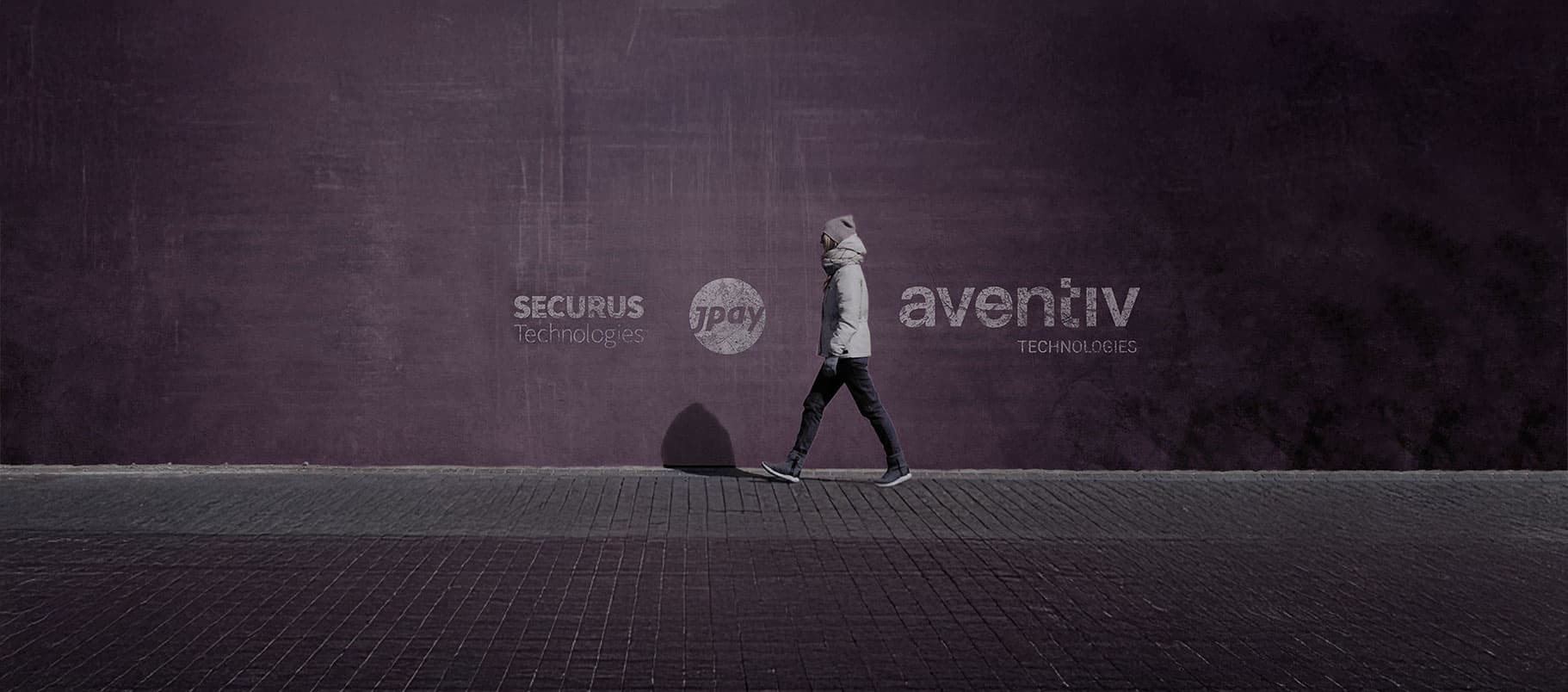 A lone figure walks along a dark, textured surface, with a large corporate logo visible in the background.